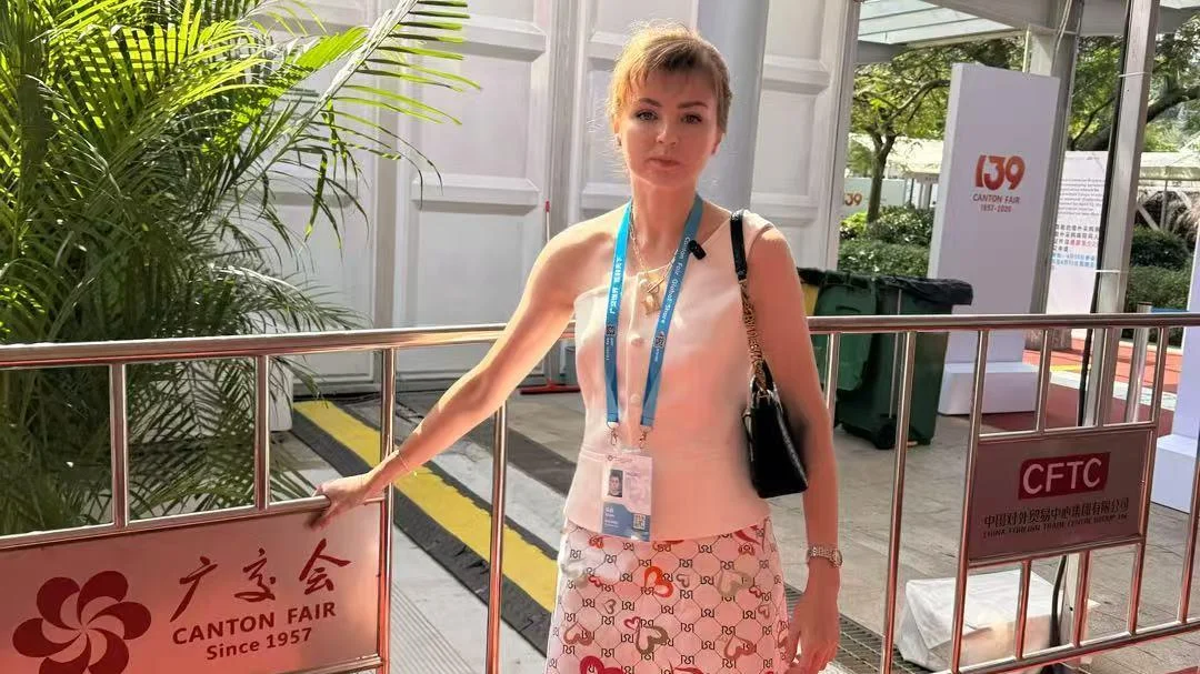 Посетитель Кантонской ярмарки в Гуанчжоу у официальной вывески Canton Fair (广交会)